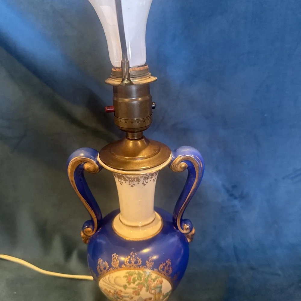 Antique porcelain urn lamp with grape-picking scene.